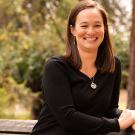 Woman sits outside on bench