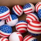 Box of red, white and blue balls patterned with U.S. flags (photograph)