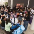 Large group of students vist tables on patio of Manetti Shrem Museum of Art