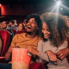 Young adults of various ethnicities watching a movie in a theater