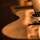 Acoustic guitar, wood, on dark background
