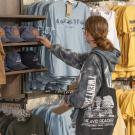 A female shopper peruses the hats, t-shirts and other apparel items of the Arneson Egghead Collection at the UC Davis Bookstore.