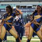 Members of the Majorettes dance group perform on the field during a football game