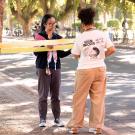 Two people tie yellow ribbon onto a tree