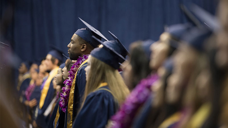 Students stand during an undergraduate commencement ceremony. (Credit?/UC Davis)